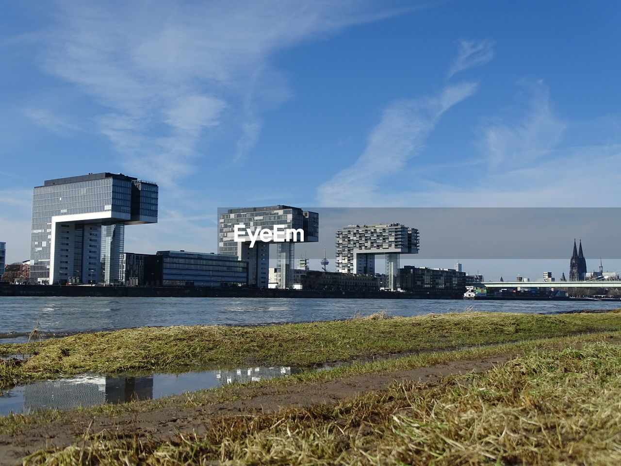 Modern buildings by sea against sky in city