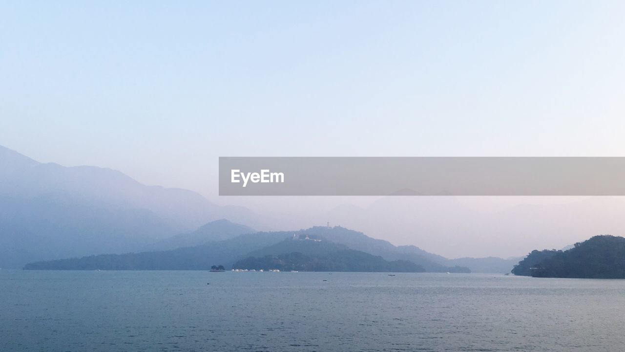 SCENIC VIEW OF MOUNTAINS BY SEA AGAINST SKY