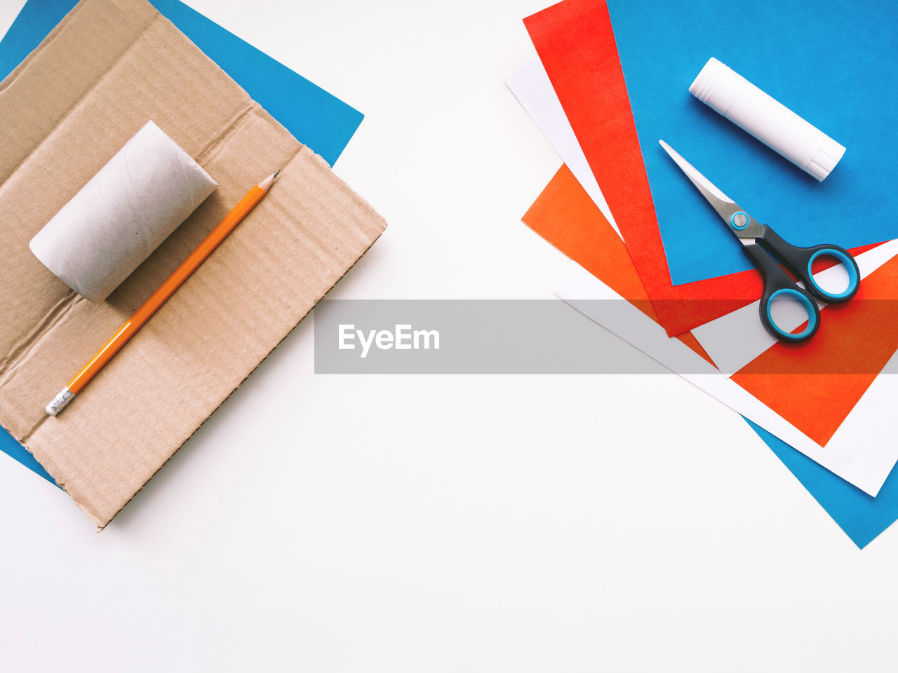 HIGH ANGLE VIEW OF COLORED PENCILS ON WHITE TABLE