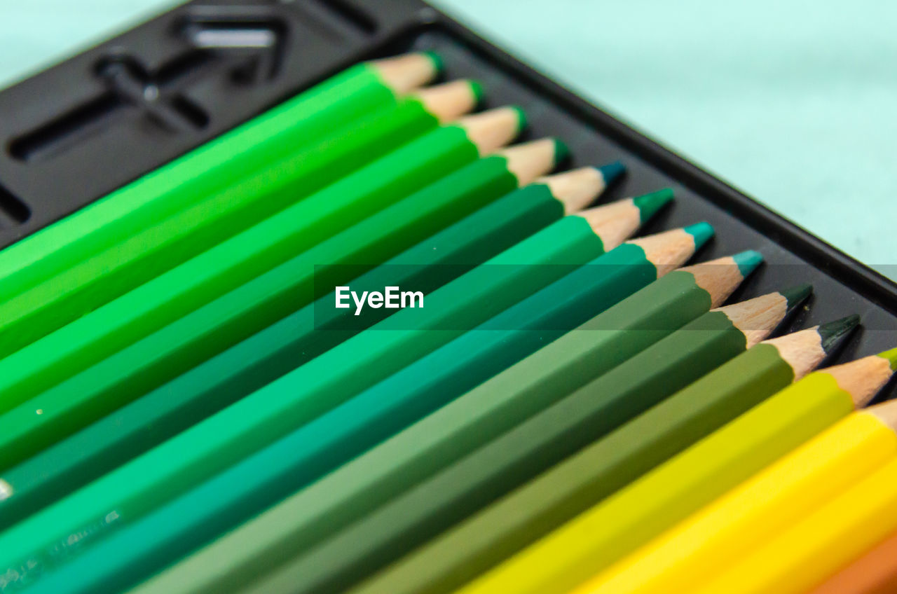 HIGH ANGLE VIEW OF COLORED PENCILS ON SHELF