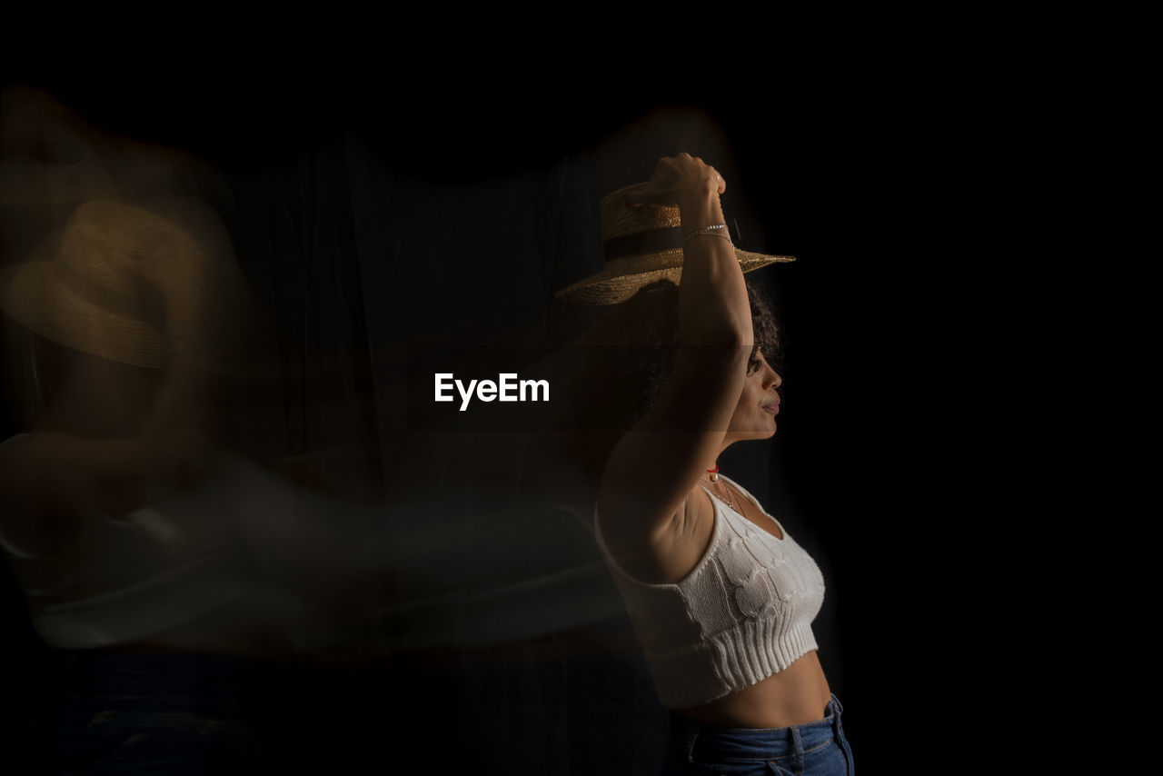 Time-lapse view of woman moving a hat. long exposure, motion blur. happy woman. salvador, brazil.