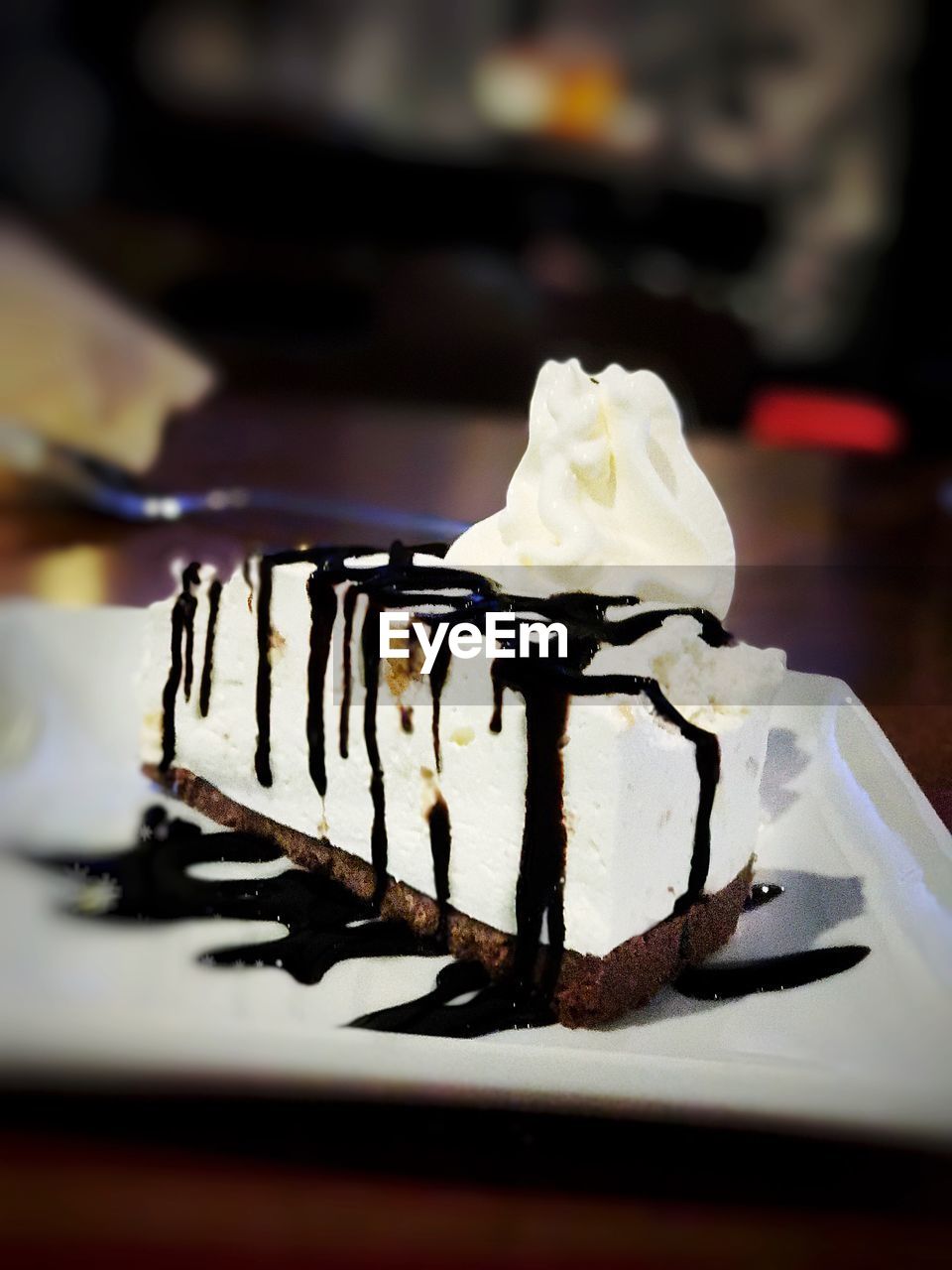 CLOSE-UP OF ICE CREAM CONE ON WOOD