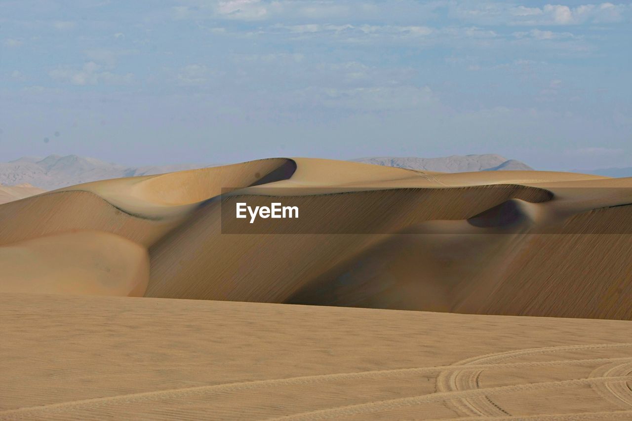 Sand dunes in desert against sky