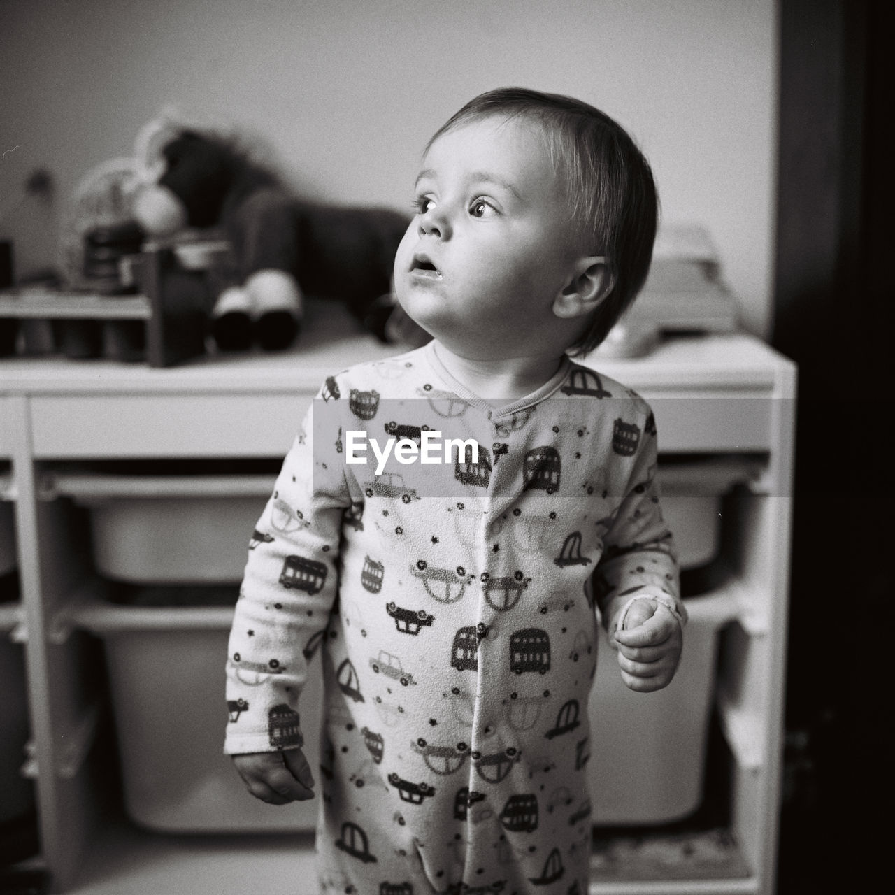 BOY LOOKING AWAY WHILE STANDING AT HOME