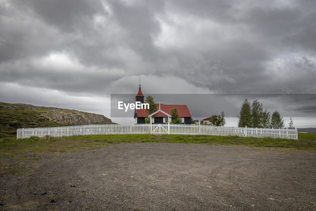 cloud, architecture, sky, built structure, building, building exterior, storm, overcast, environment, nature, storm cloud, dramatic sky, landscape, tower, house, travel destinations, no people, religion, moody sky, travel, land, coast, hill, sea, water, rural area, history, place of worship, cloudscape, outdoors, beach, the past, tourism, plant, city, belief, scenics - nature, horizon, grass, beauty in nature, road, rural scene