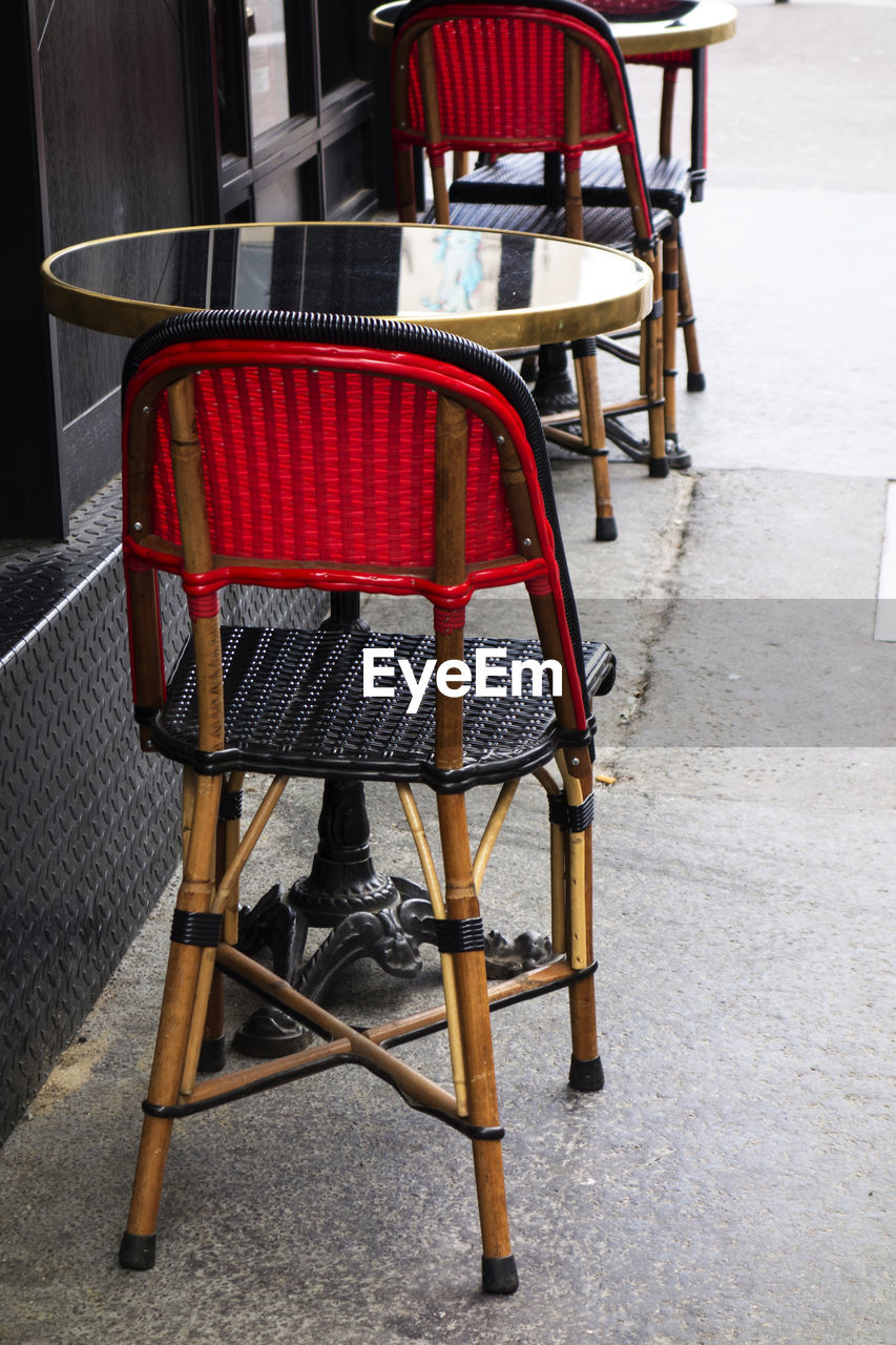 Empty chairs and table at sidewalk cafe