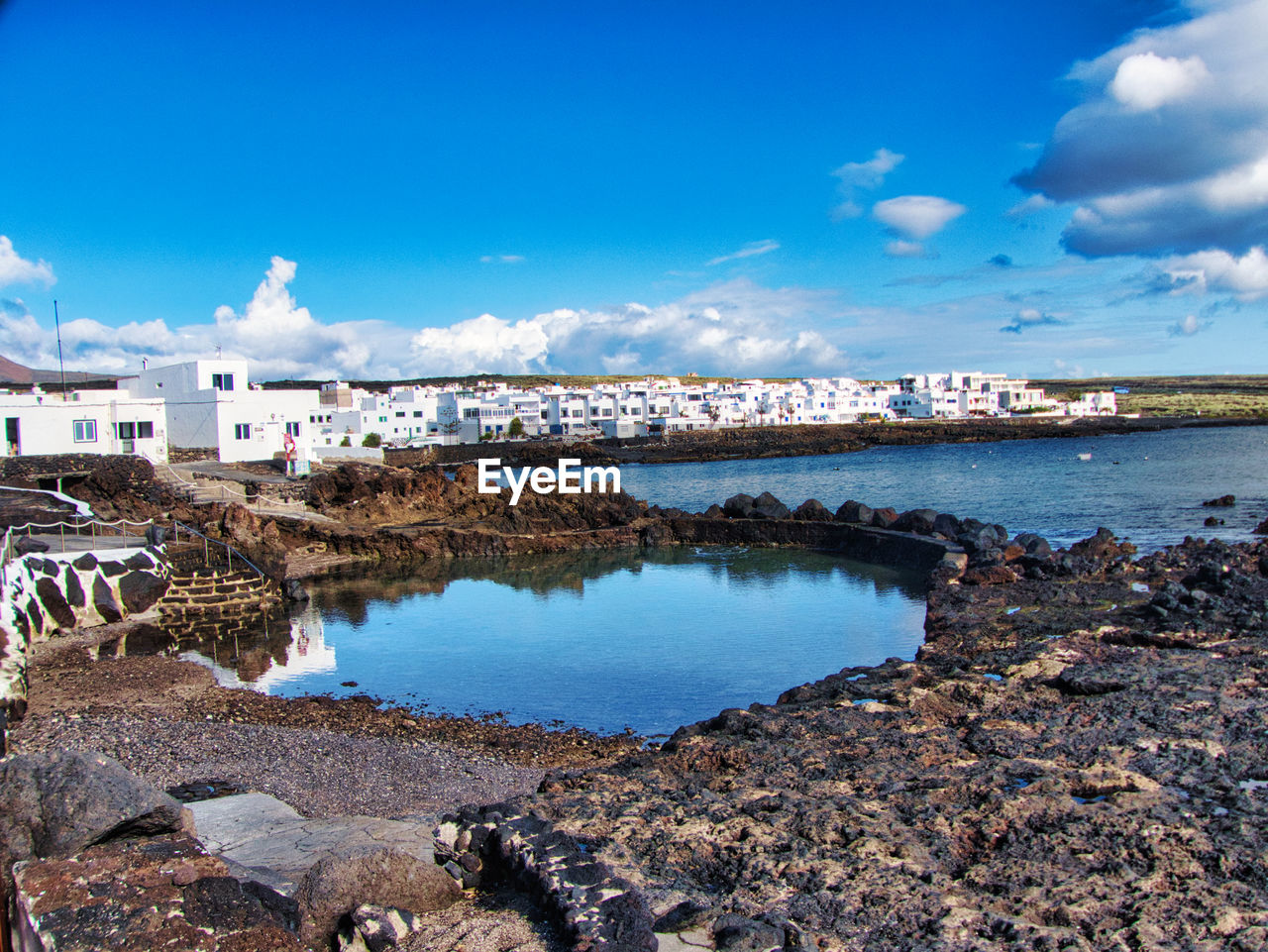 Scenic view of sea and buildings against sky