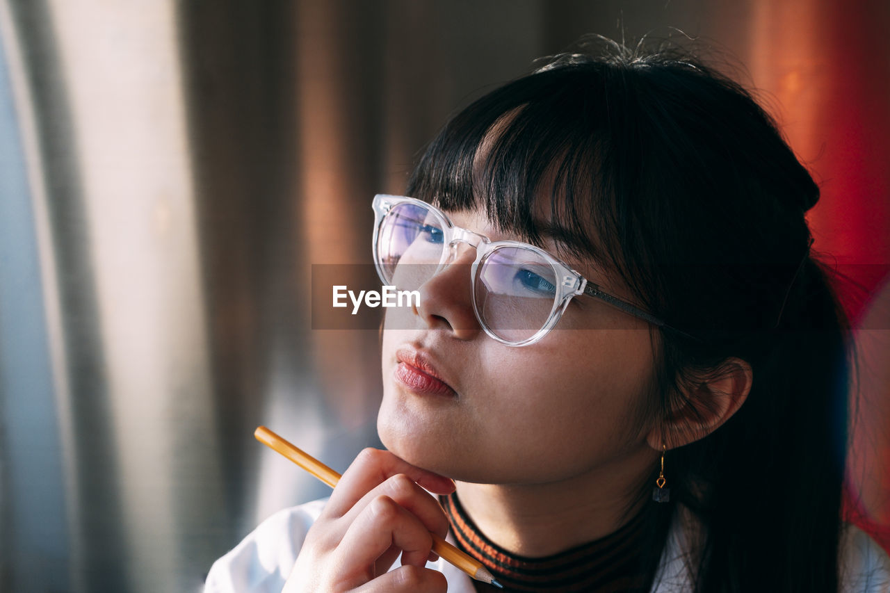 Young chemist wearing eyeglasses contemplating in laboratory