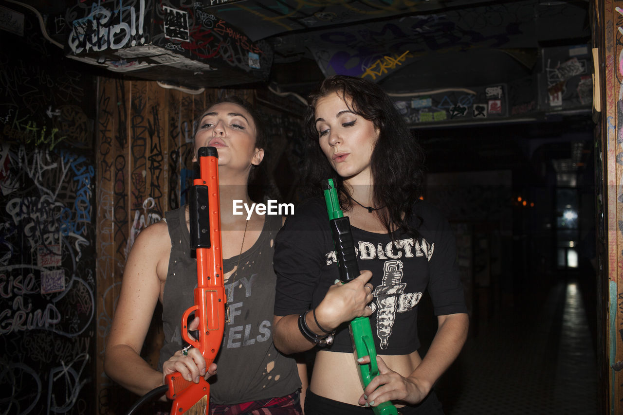 Young women playing with plastic guns