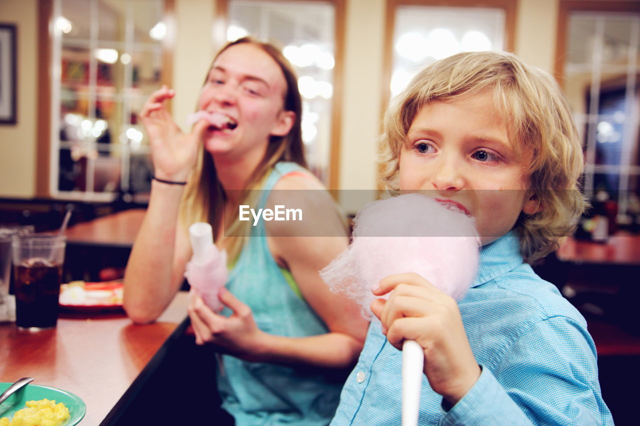 Mother with son eating cotton candy at restaurant