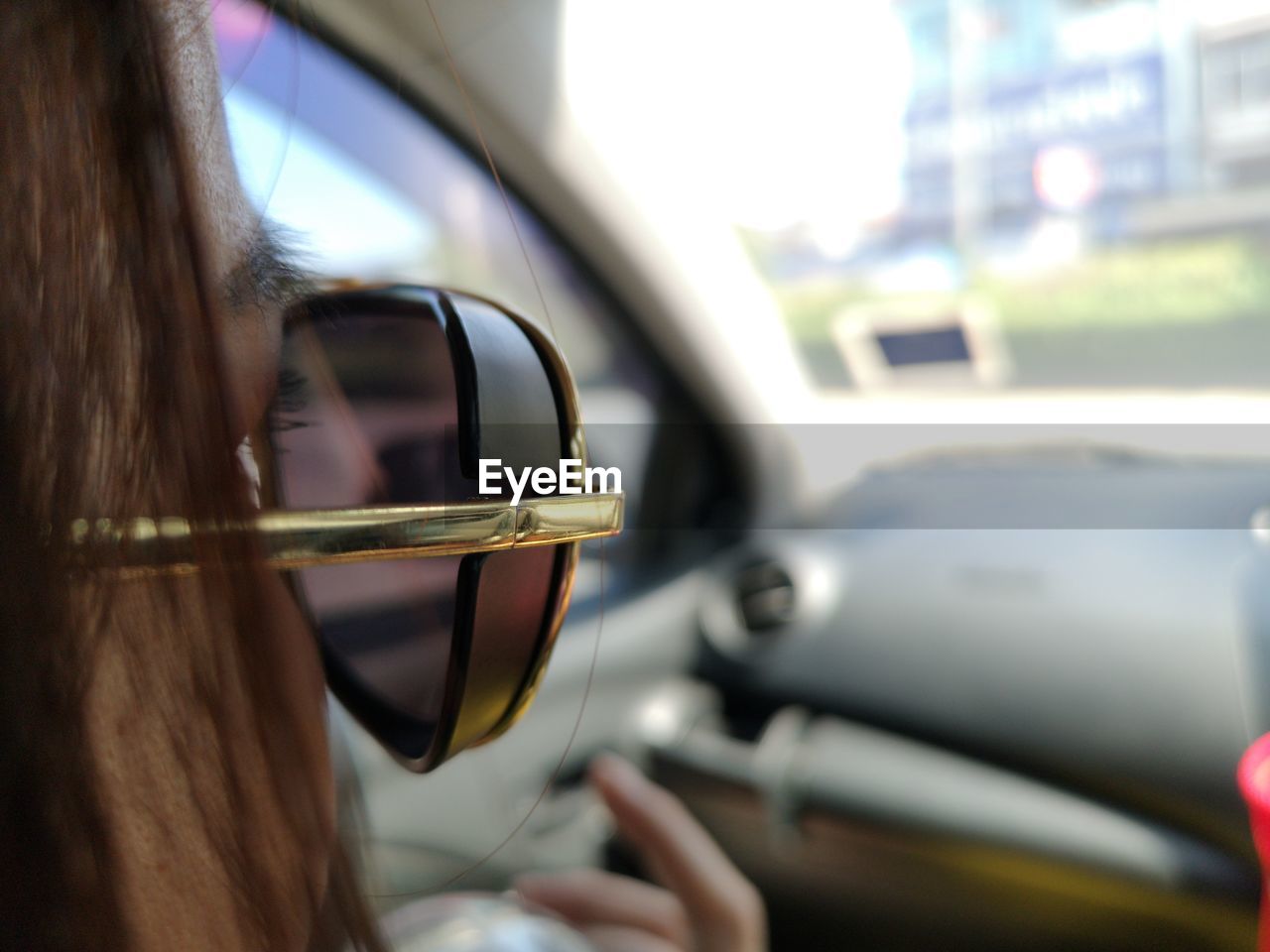 Close-up of woman wearing sunglasses while sitting in car