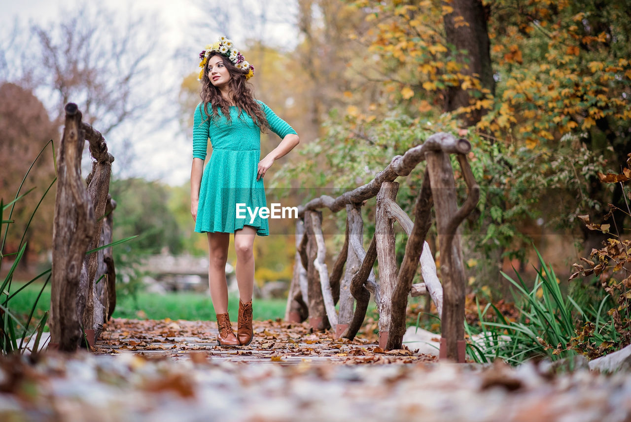 Full length of woman standing by tree