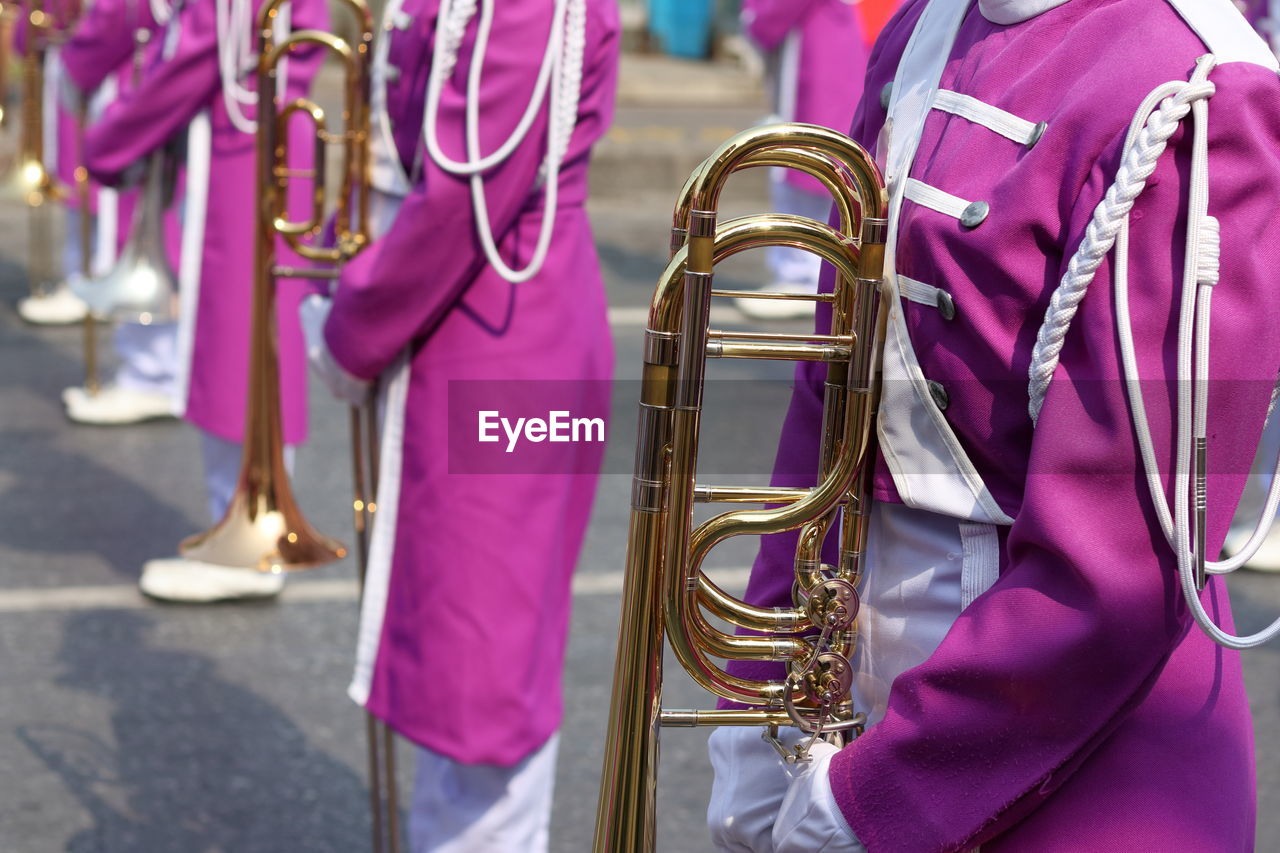 Midsection of marching band on street