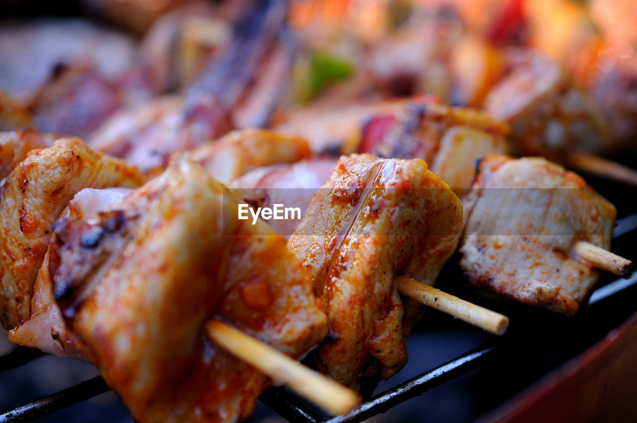 Close-up of meat in skewers on barbecue grill