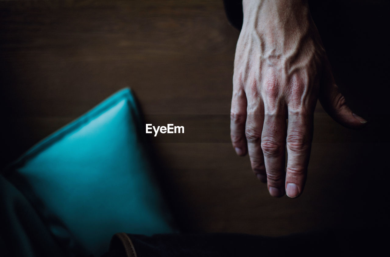 Cropped hand of man over wooden table