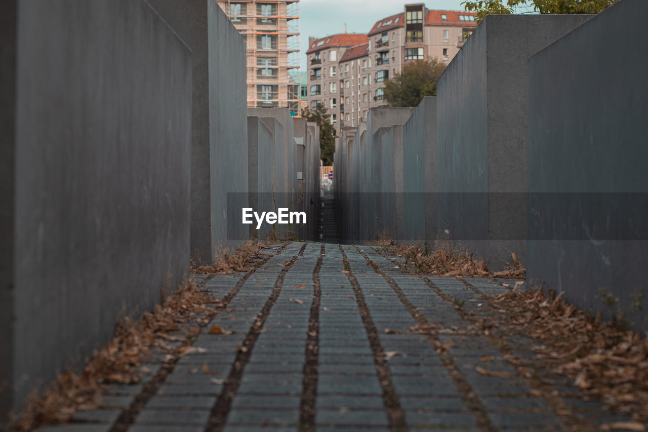 empty footpath amidst buildings in city