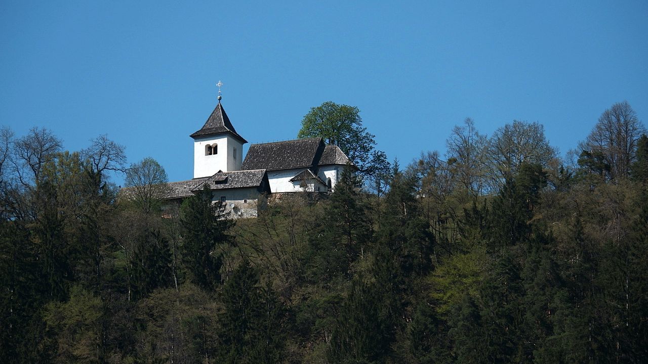 Low angle view of trees and building against clear blue sky