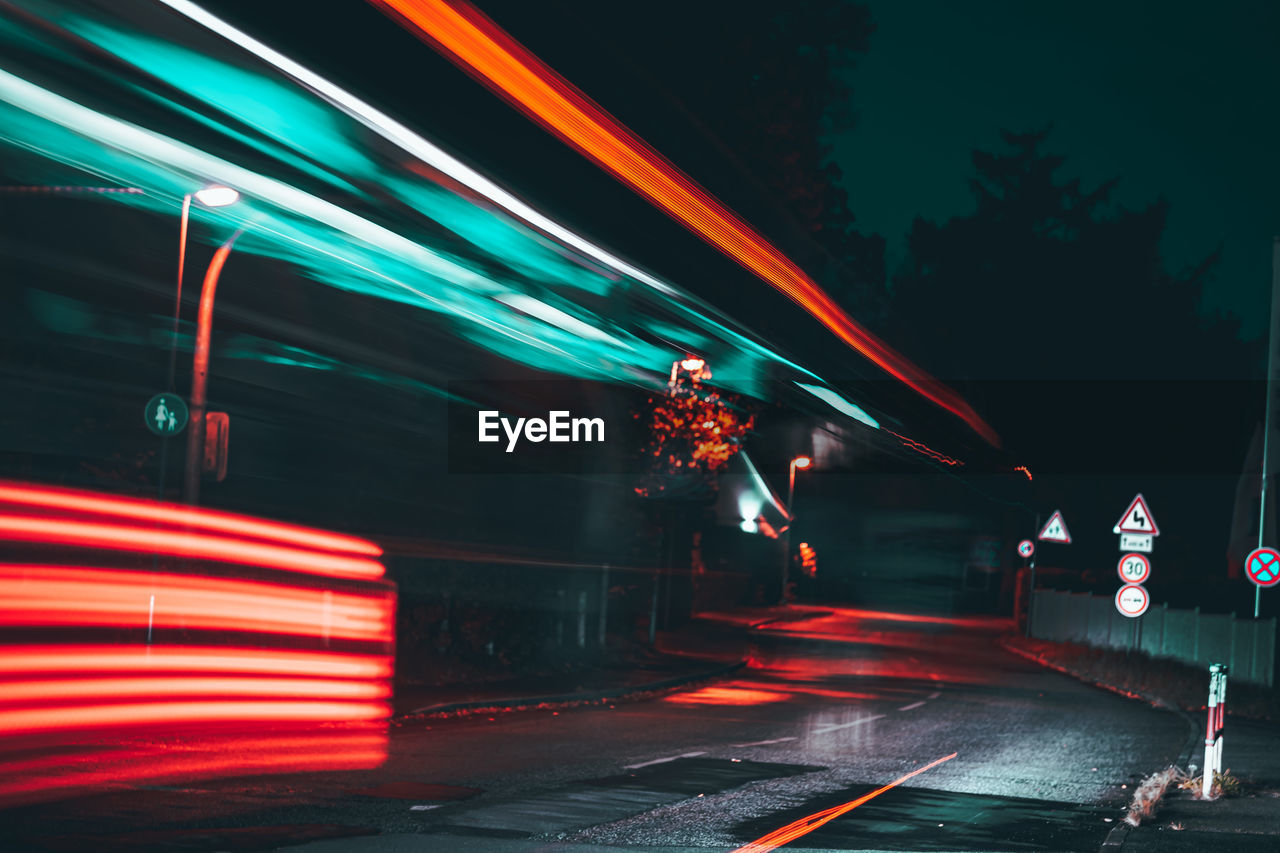 BLURRED MOTION OF LIGHT TRAILS ON ROAD AT NIGHT