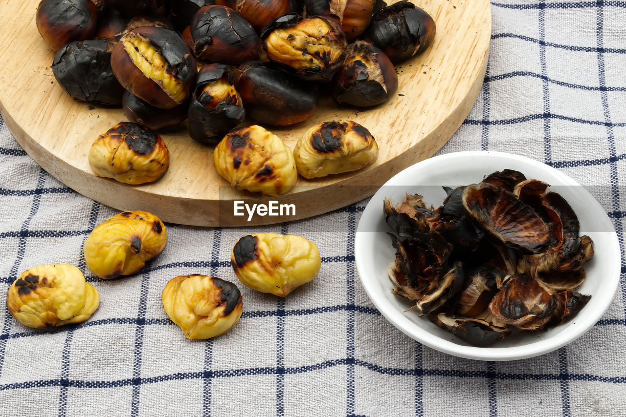 Fresh roasted chestnuts on a table with peels. close-up