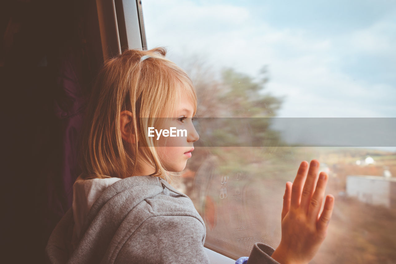 Close-up of girl looking through train window