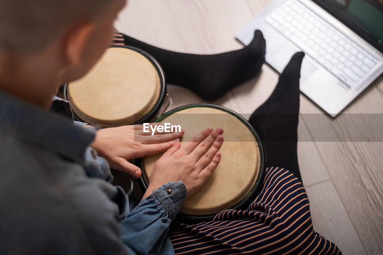 High angle view of woman playing drum