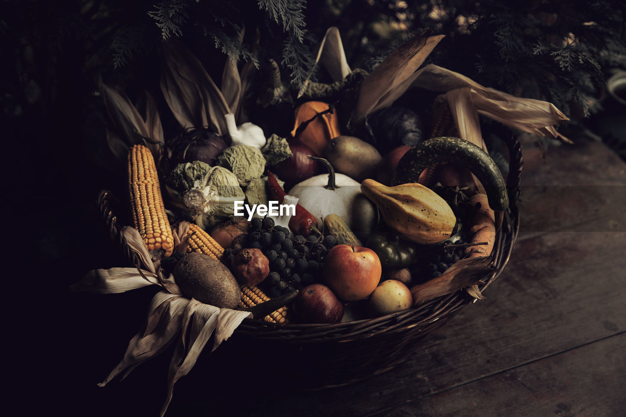 FRUITS IN BASKET ON WOODEN TABLE