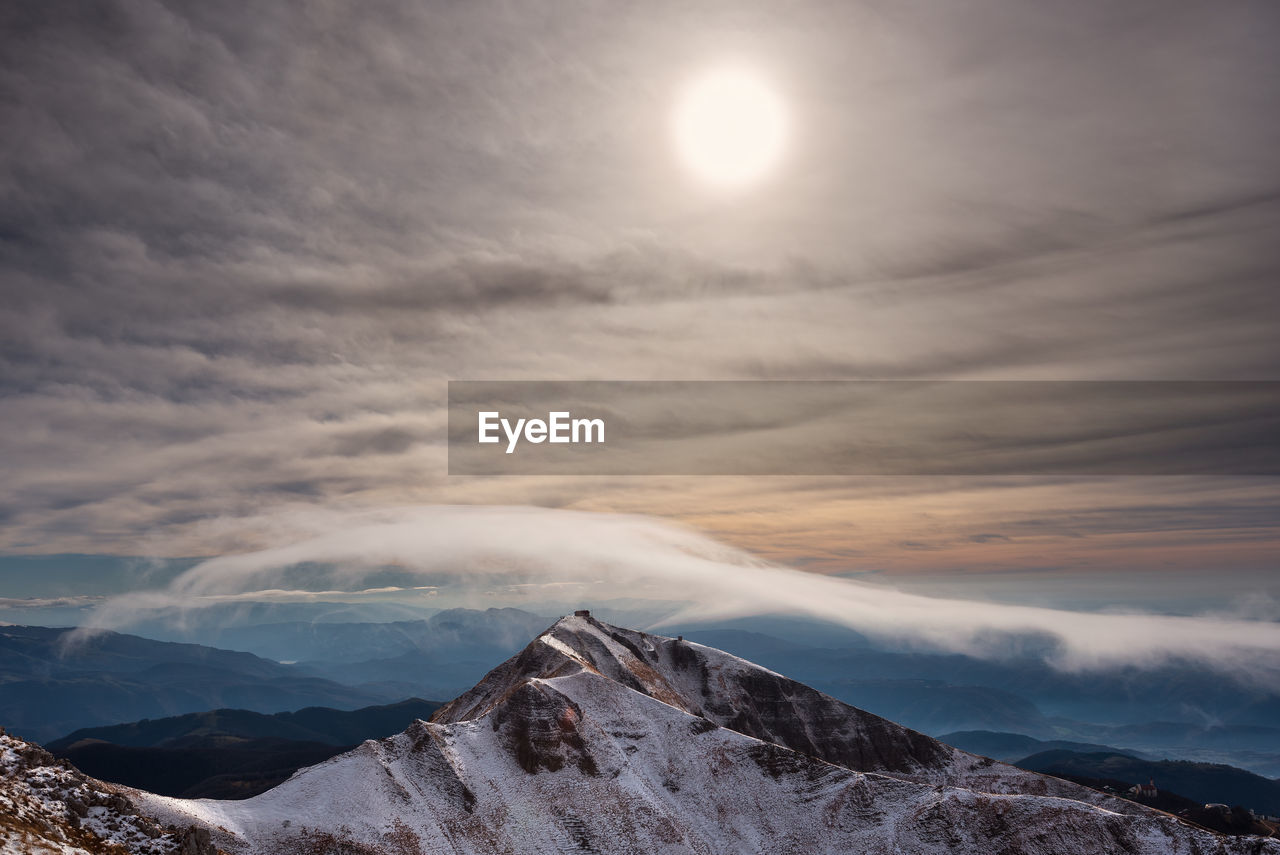 Scenic view of snowcapped mountains against sky during sunset