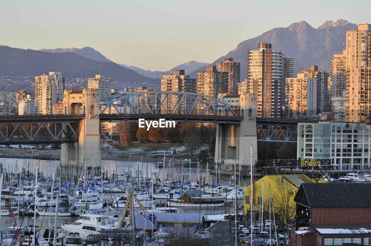 Cityscape by river against sky