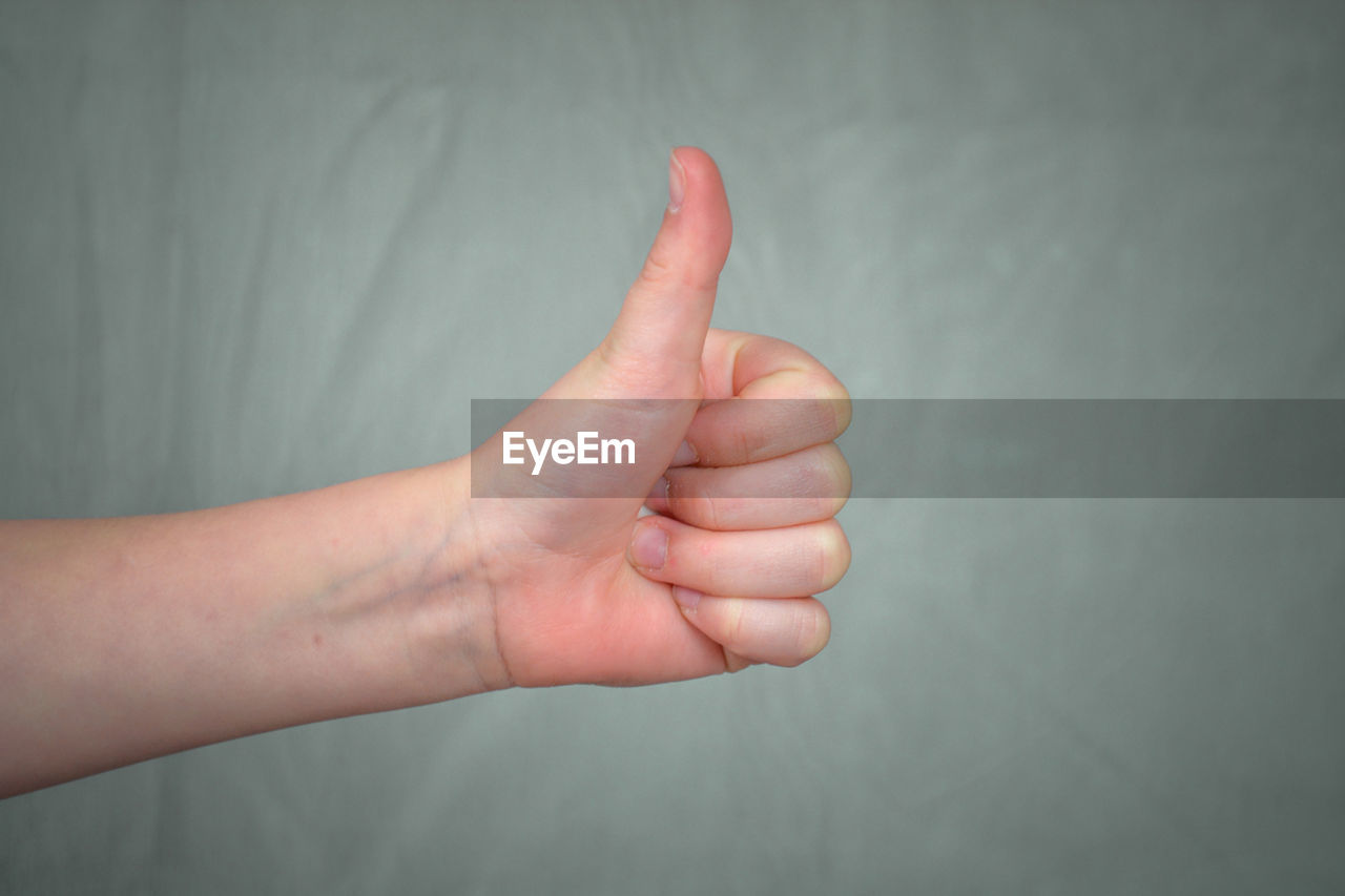 Close-up of human hand over background