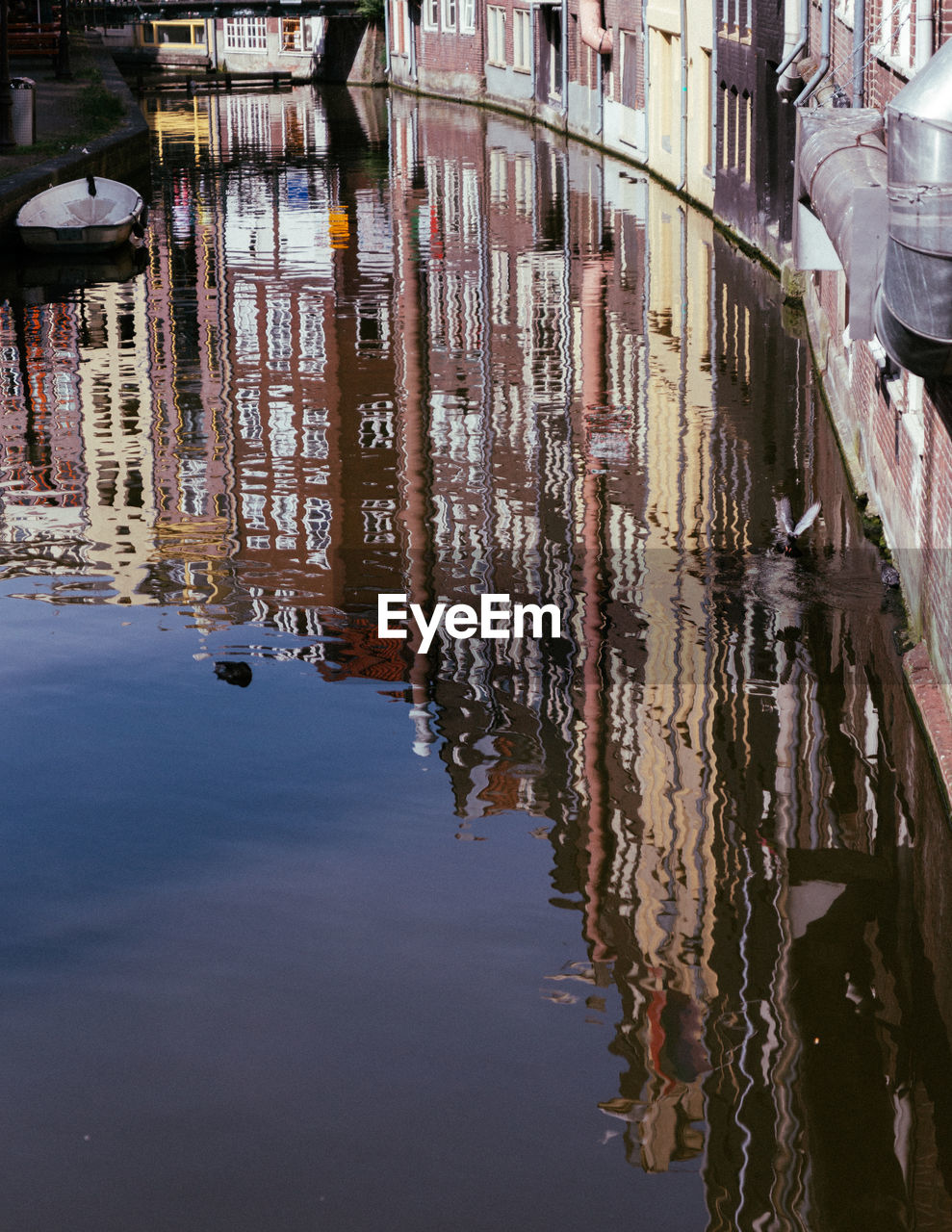 Reflection of buildings in puddle on canal