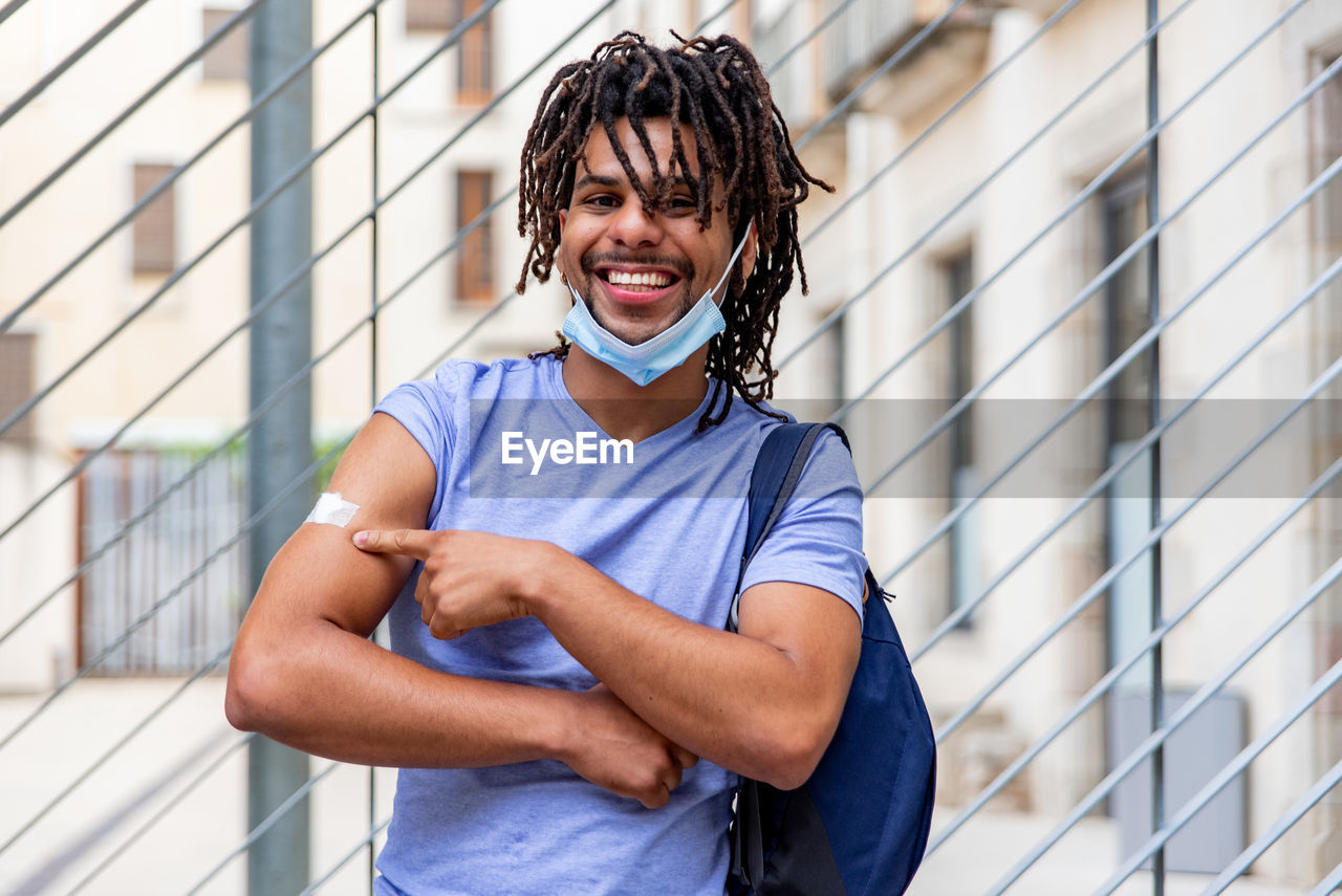 Young latin man vaccinated showing his arm