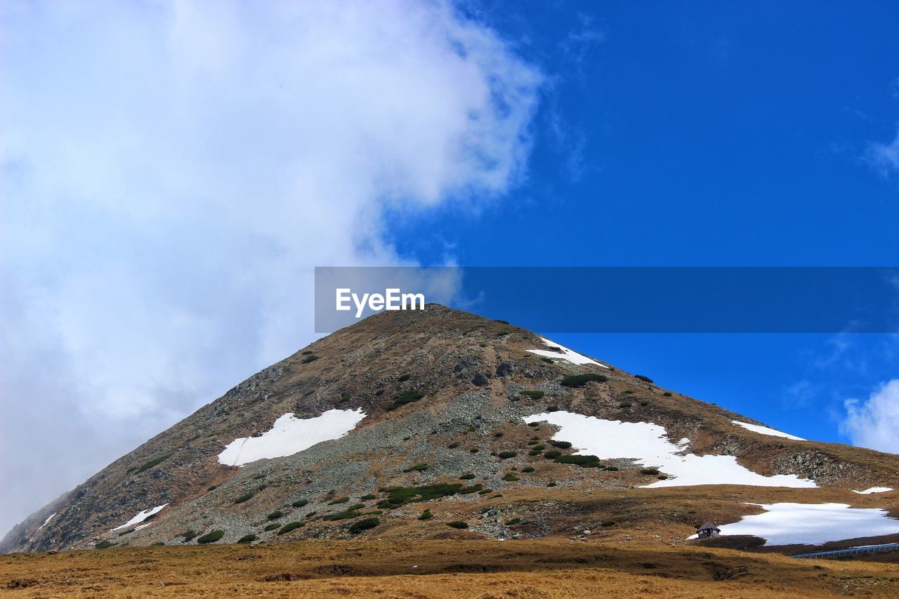 LOW ANGLE VIEW OF SNOW COVERED MOUNTAIN AGAINST BLUE SKY