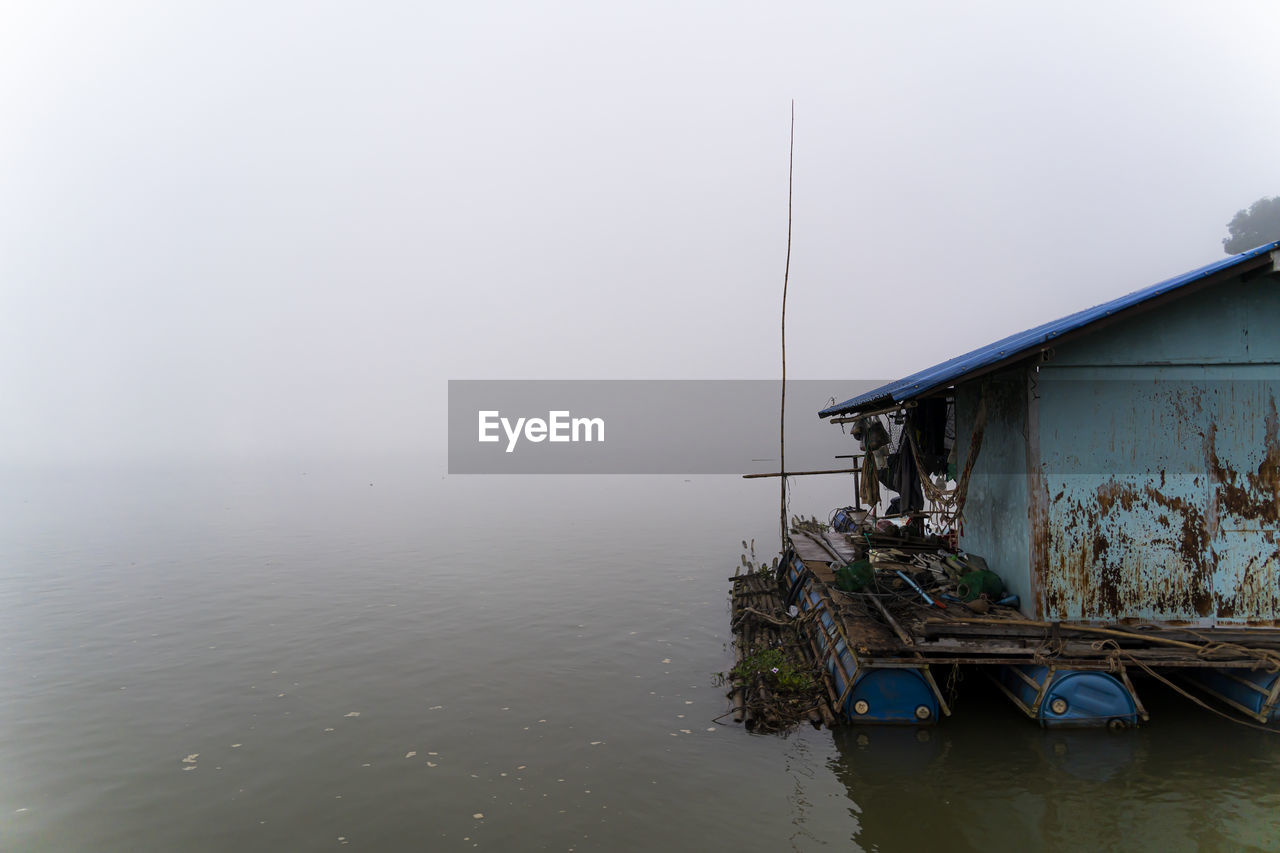 water, nature, fog, architecture, sea, sky, built structure, no people, nautical vessel, house, stilt house, building exterior, tranquility, day, building, transportation, outdoors, vehicle, reflection, environment, tranquil scene, fishing, scenics - nature, wood, beauty in nature, copy space, hut, residential district, landscape, mode of transportation, rural scene, non-urban scene