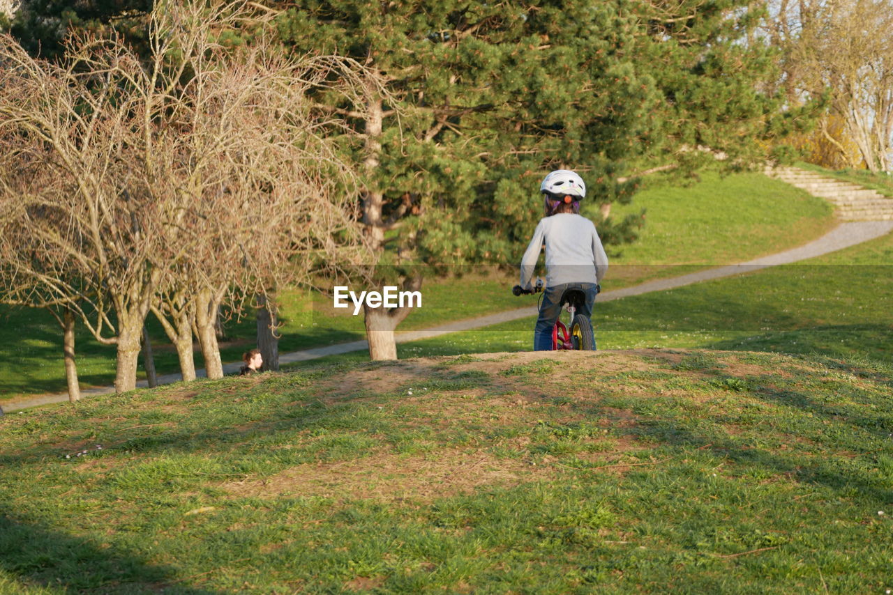 Rear view of girl riding bicycle at park