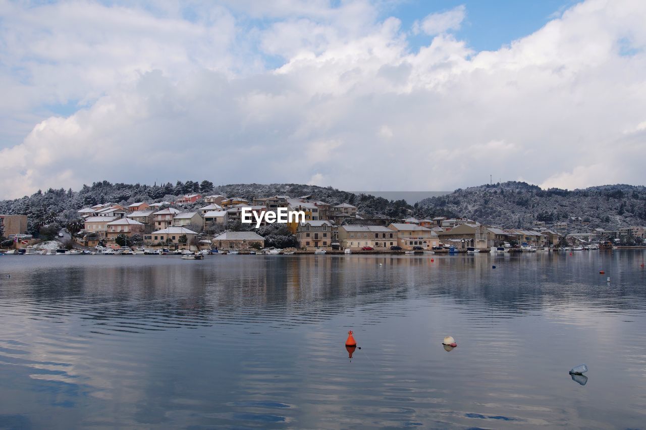 Scenic view of sea and buildings against sky