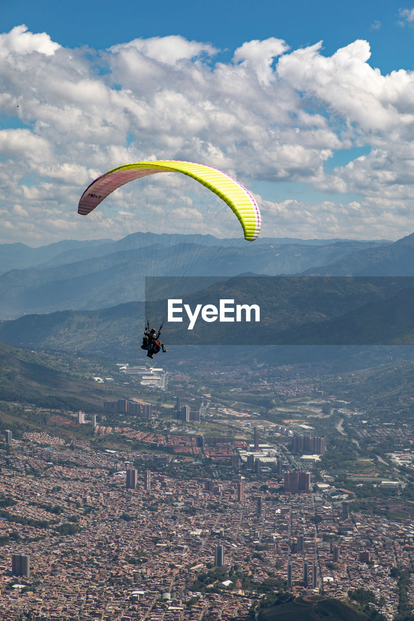 Person paragliding over townscape