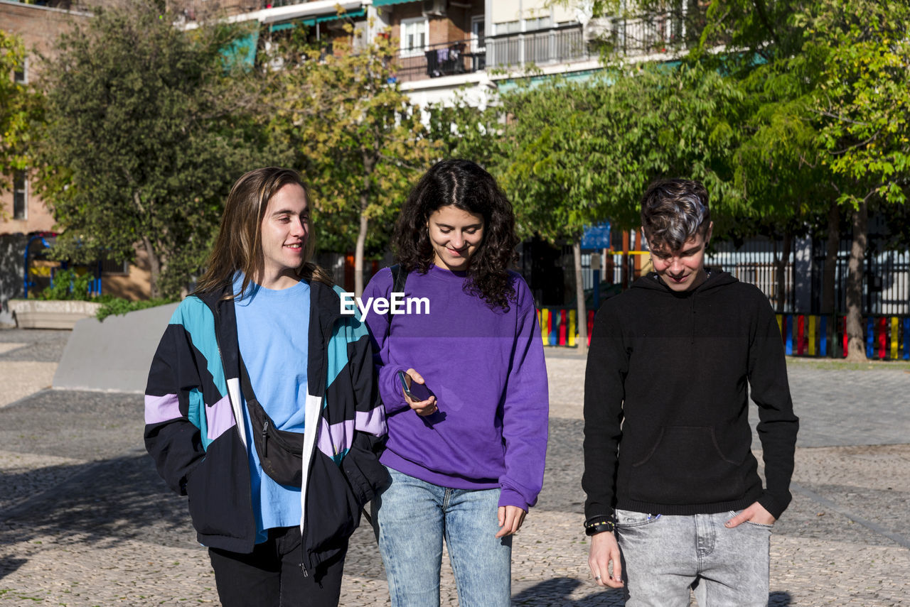 Young diverse friends walking outdoors on the street.