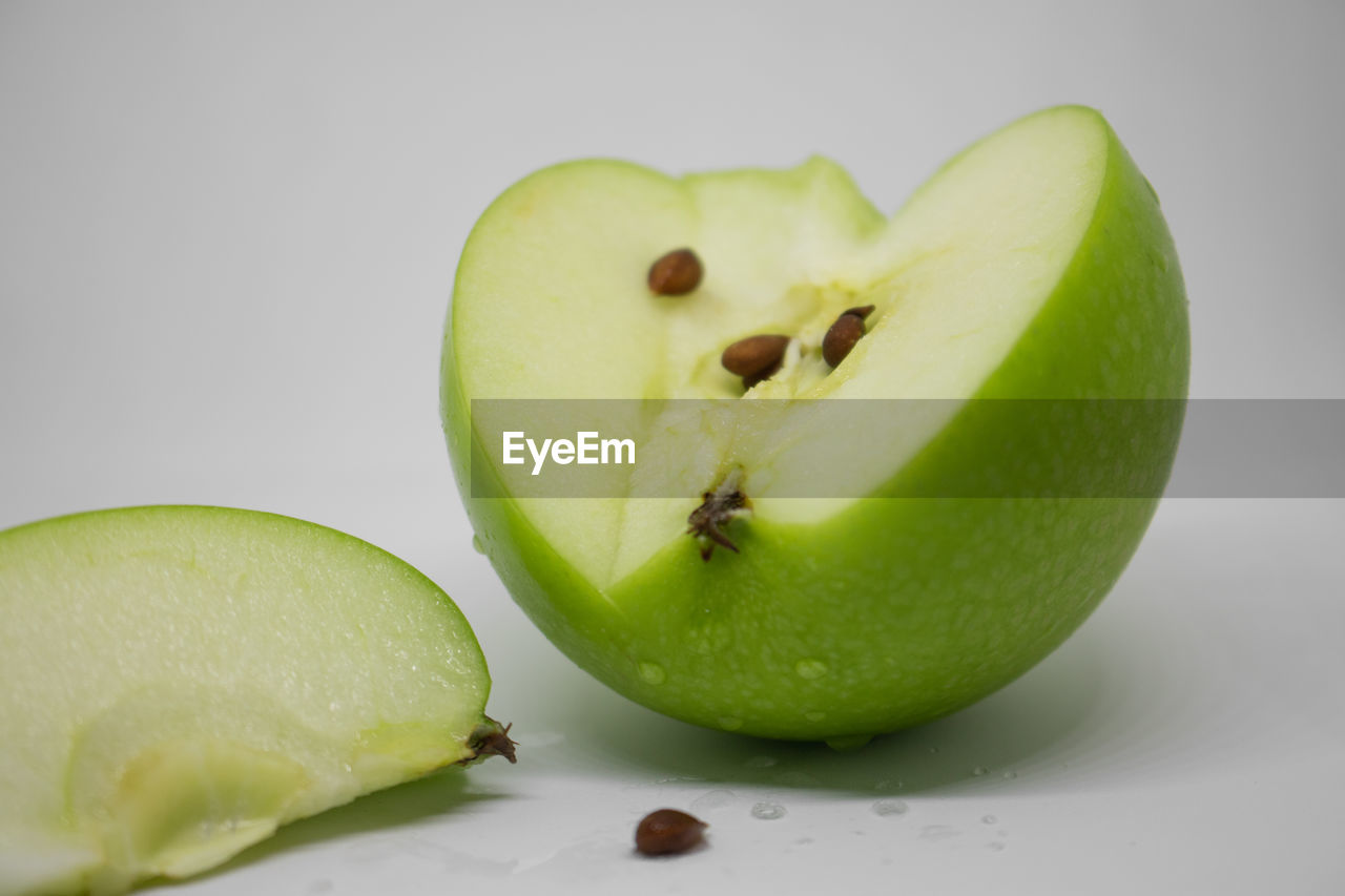 CLOSE-UP OF APPLE ON GREEN BACKGROUND