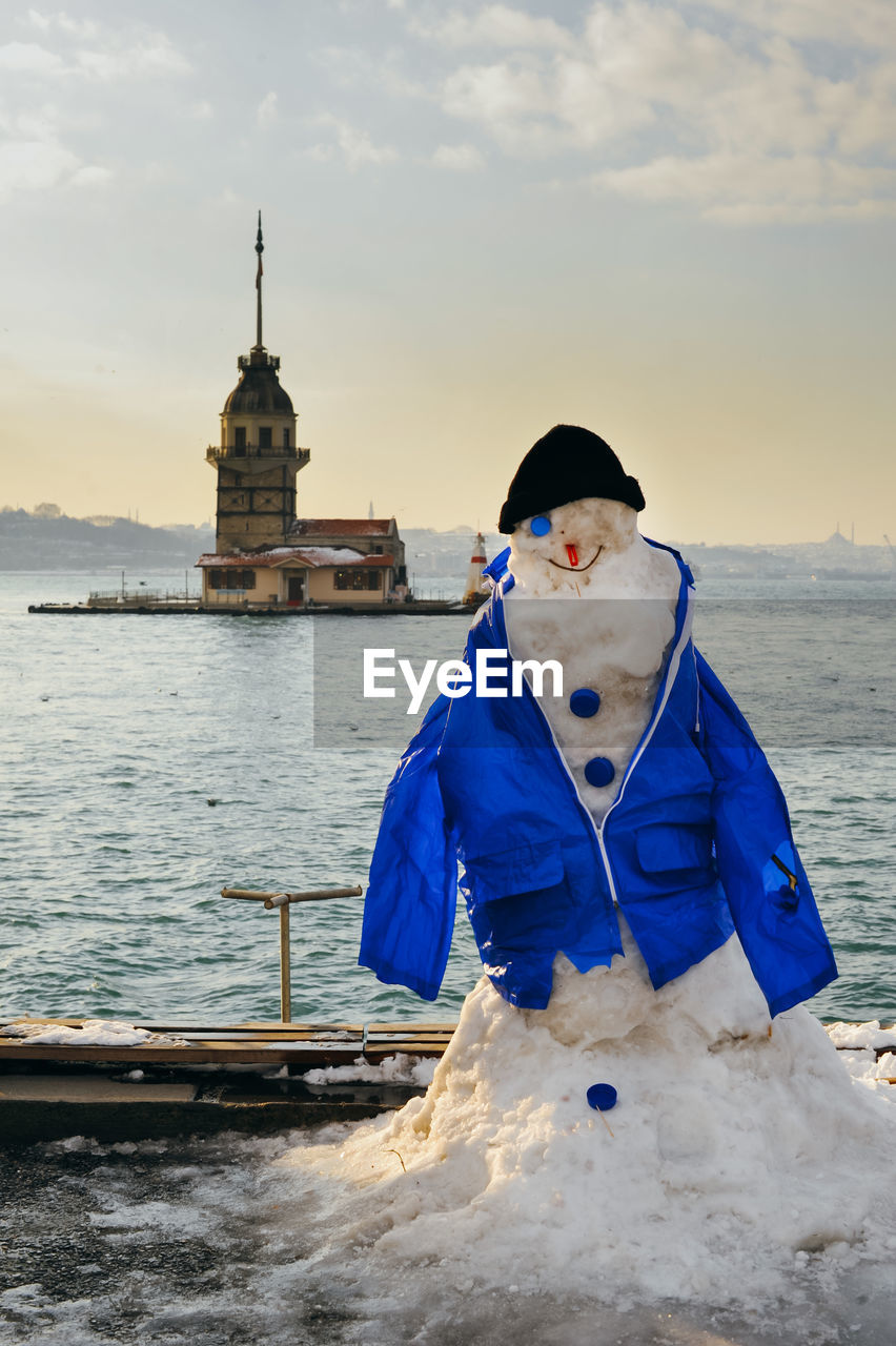 Snowman against maiden tower during winter