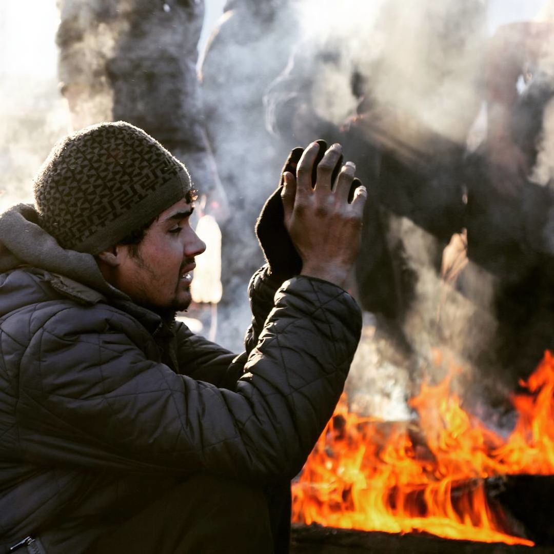 MIDSECTION OF MAN WITH FIRE IN BACKGROUND