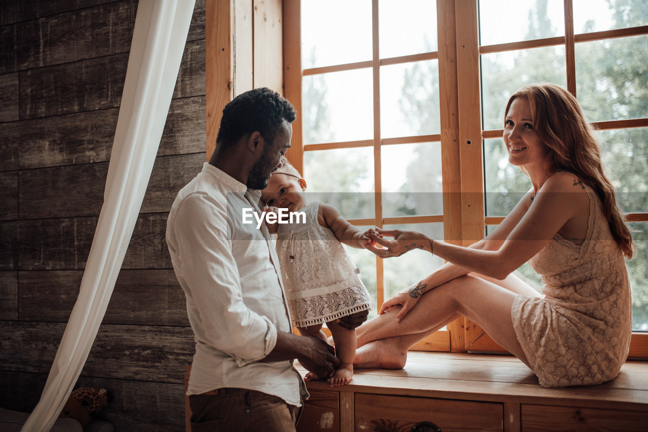 Young couple sitting on window