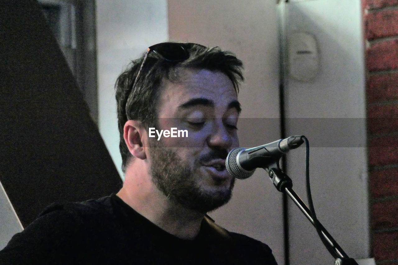 input device, microphone, music, performance, singing, one person, musician, singer, arts culture and entertainment, adult, headshot, men, young adult, indoors, recording studio, portrait, studio, person, concert, eyes closed, beard, musical instrument, lifestyles, leisure activity, facial hair, entertainment, human face