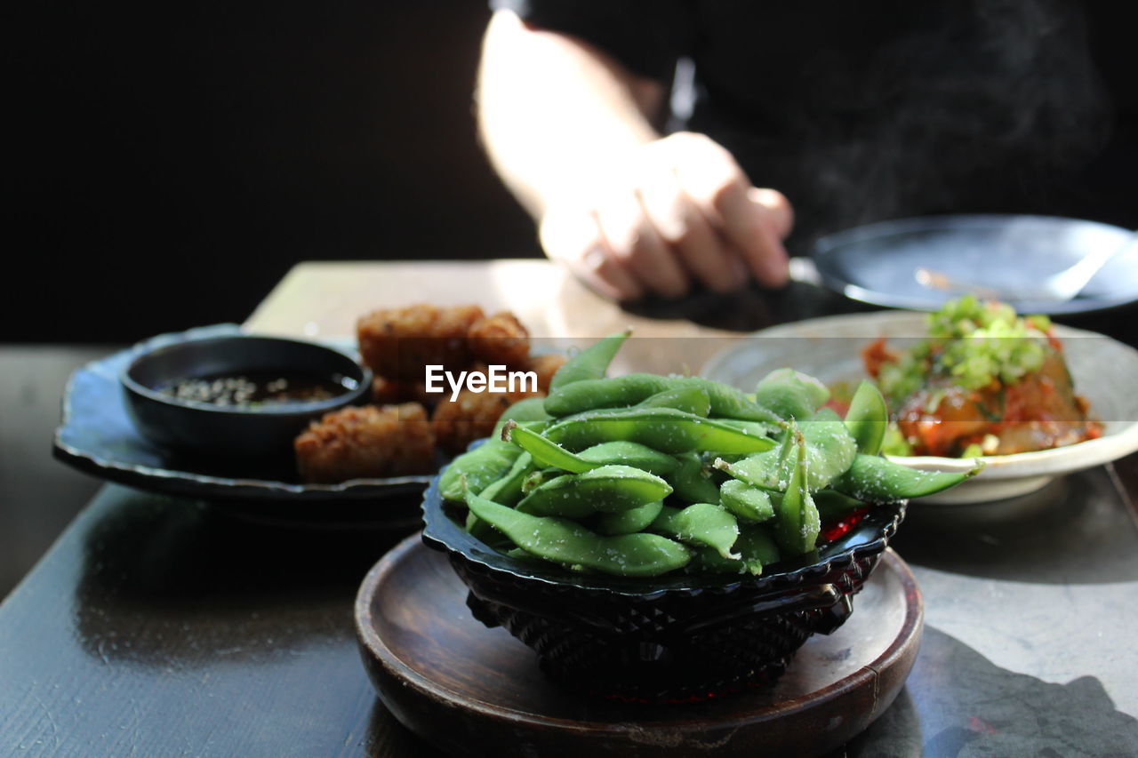 Cropped image of man eating food at table