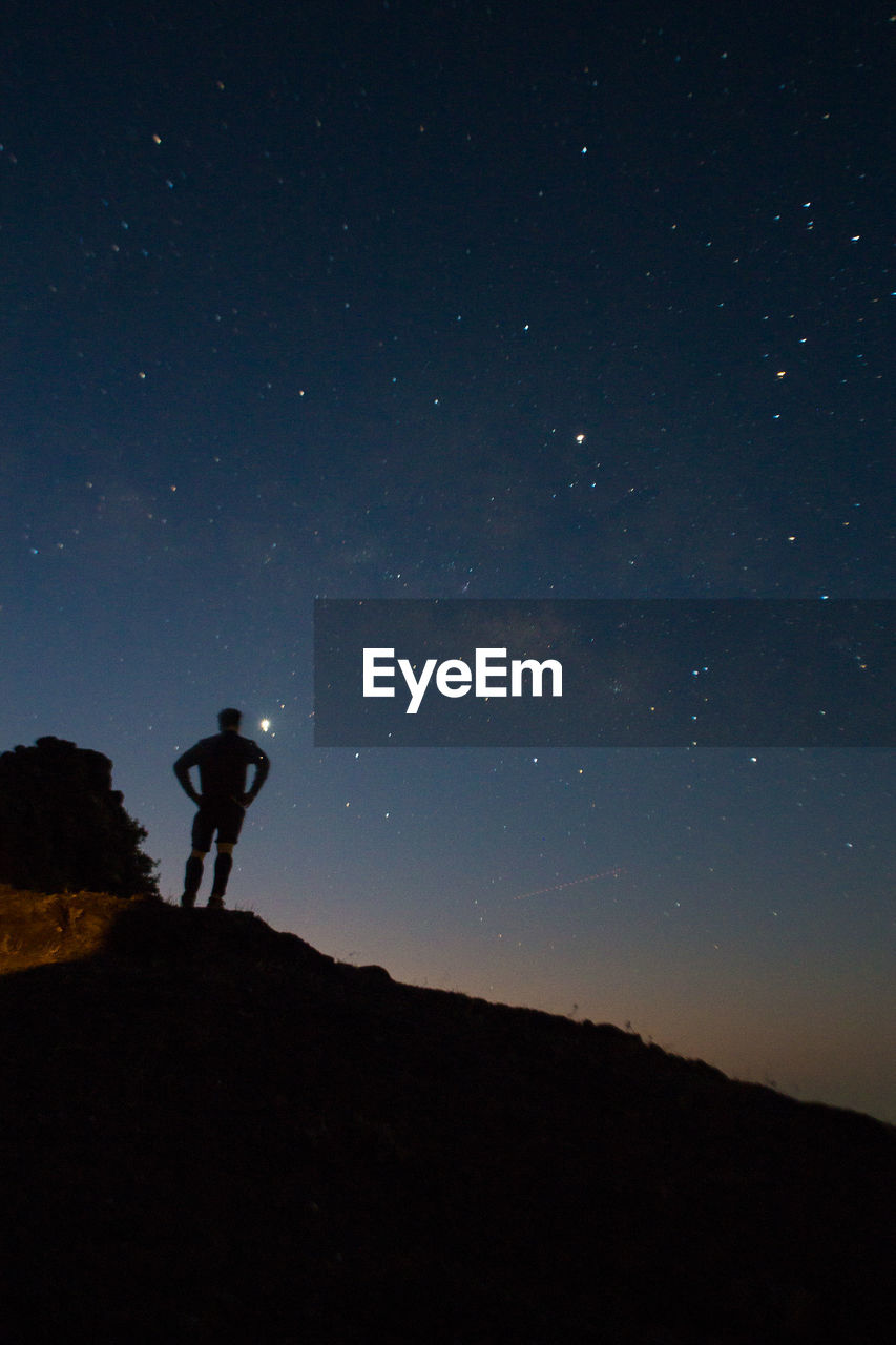 LOW ANGLE VIEW OF SILHOUETTE PEOPLE STANDING ON MOUNTAIN AGAINST SKY