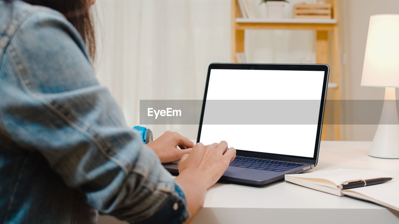 Midsection of woman using laptop