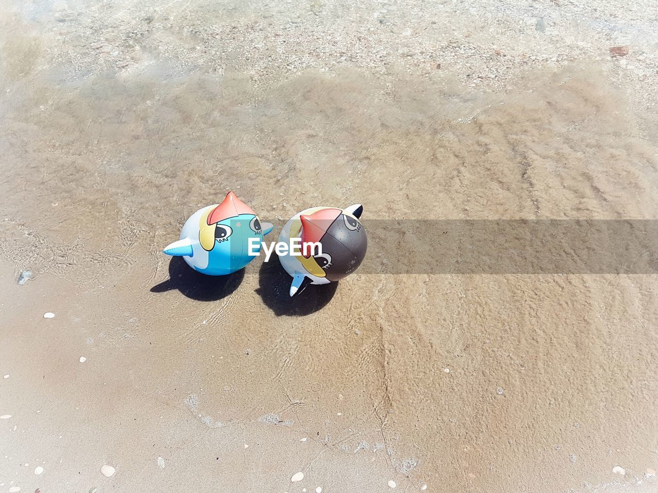 HIGH ANGLE VIEW OF TOYS ON BEACH