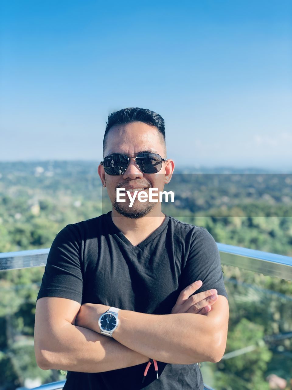 Portrait of young man wearing sunglasses against forest 