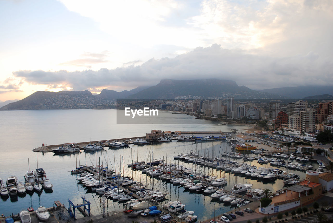 water, architecture, sky, transportation, city, sea, nautical vessel, harbor, nature, building exterior, built structure, building, cloud, high angle view, mode of transportation, travel destinations, ship, cityscape, pier, coast, travel, marina, sunset, no people, outdoors, dock, business, mountain, landscape, scenics - nature, sunlight, tourism, land, horizon, beauty in nature, commercial dock, beach, port, moored, aerial photography, freight transportation, bay of water, aerial view, vehicle, holiday, bay, day, residential district, vacation, dusk, environment