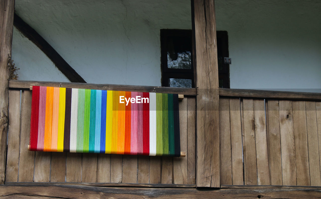 Colorful wood hanging on wooden railing