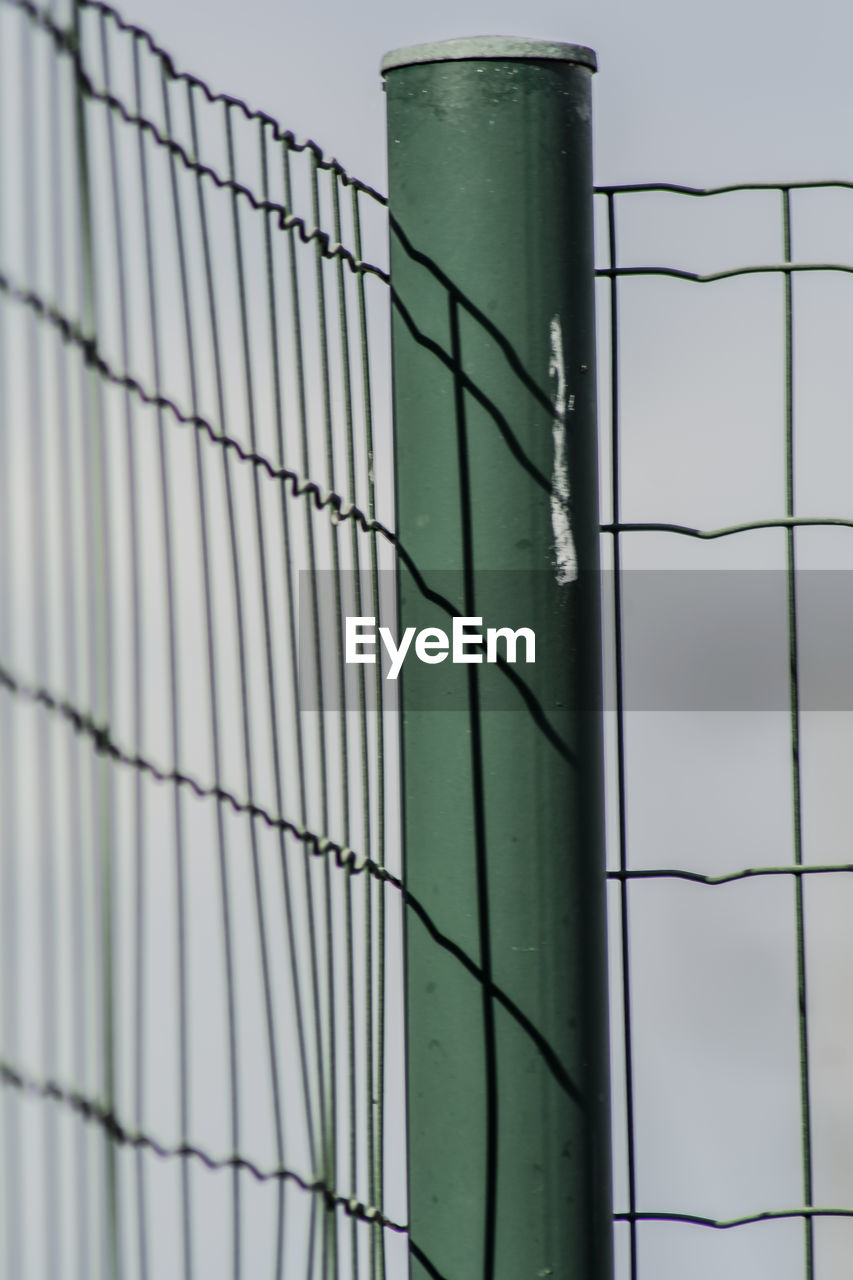 Metal fence against sky